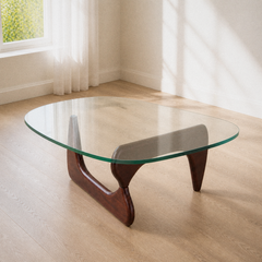 Angle | same living room, three-quarter view of the triangular glass top and sculptural wood base