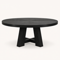 Front | round black trestle dining table centered on paper studio background, front elevation