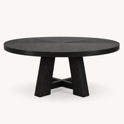 Front | round black trestle dining table centered on paper studio background, front elevation