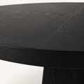 Closer | the round top's flat matte black finish and its visible wood grain