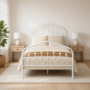 Airy room | White spindle bed centered in a bright room with light wood nightstands and a leafy plant