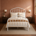 Clay room | White spindle bed against a clay colored wall with brass sconces and dark wood nightstands