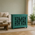 Sage room | antique teal-green painted cabinet with two lattice glass doors on a plain oatmeal rug beside a cream sofa and window