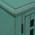Finish macro | distressed teal-green paint, rub-through at a molded top corner and dark hinge