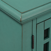Finish macro | distressed teal-green paint, rub-through at a molded top corner and dark hinge