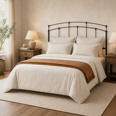 Room 1 angle | Three-quarter bedroom view showing the double curved rails and rounded finials