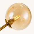 Detail | one amber glass globe, its brass mount, and the capsule bulb