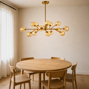 In a room | 15-globe amber and gold sputnik chandelier hanging over a round oak dining table, morning light
