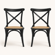 Front | both black cross-back rattan side chairs centered on paper, matte black frame and natural rattan seats visible