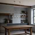 In a room | polished chrome 6-light linear chandelier over an oak work table in a cool blue-gray beamed kitchen