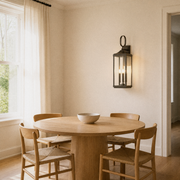 Dining room | Antique bronze aluminum wall lantern beside a pale oak dining table