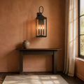Clay room | Antique bronze wall lantern on a clay wall above a dark console