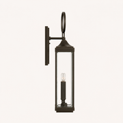 Side profile | Antique bronze wall lantern showing the backplate, support arm, side glass, and oval loop