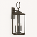 Three-quarter | Antique bronze wall lantern showing the clear glass cage and rectangular wall backplate