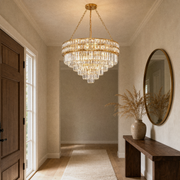 In a room | gold crystal chandelier in an entryway with a console table