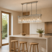Scale | marnau Baluden 8-Light Crystal Pendant over a kitchen island with doorway for scale