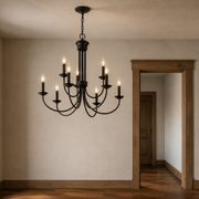 Scale | dark bronze nine-light chandelier beside a full-height wood-trimmed doorway