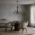 In a room | dark bronze nine-light chandelier over a round dark wood table in a cool limewash dining room