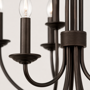 Close detail | dark bronze steel candle sleeve, bobeche, curved arm, and ribbed center band