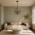 Living room | English Bronze globe chandelier above a round stone coffee table