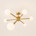Side | brushed brass six-globe semi-flush fixture from a low corner studio angle