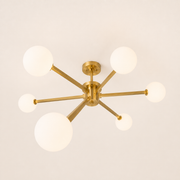 Side | brushed brass six-globe semi-flush fixture from a low corner studio angle