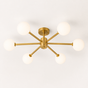 Studio | brushed brass six-globe semi-flush fixture from an elevated three-quarter studio angle