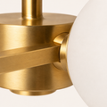 Texture | close view of a brushed brass arm, hub connector, and frosted glass globe edge