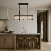 In scale | pendant over a kitchen island with a full-height doorway visible on the right