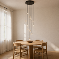 In a room | black 12-light crystal cluster hanging over a round oak dining table