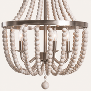 Hardware | close view of three candle sockets, the brushed-steel hub and weathered white bead strands