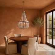 In a room | weathered white wood-bead chandelier over a walnut table in a terracotta room with French doors