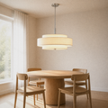 Dining room angle | off-white three-drum chandelier over a round pale-oak table