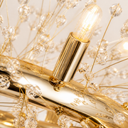 Hardware | close view of a gold-tone cylindrical socket, clear bulb, crystal branch, and ring