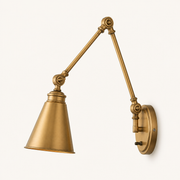 Studio side profile | warm brass swing-arm sconce showing the arm projection, cone shade profile, circular backplate depth, and switch