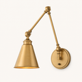Studio three-quarter | warm brass swing-arm sconce showing the two arm joints, cone shade, backplate thickness, and switch