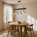 Dining room three-quarter view | eight-bulb pendant over a round oak table