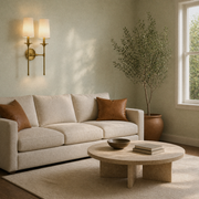 Cool living | two-light wall sconce in rubbed brass with off-white linen shades above a sofa