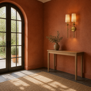 Terracotta room | two-light rubbed brass wall sconce beside a console