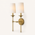 Studio angle | three-quarter view of the two shades, brass stems, crossbar, and round backplate