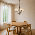 Dining room angle | corner view of the brushed nickel five-light chandelier over a round oak table beside a left window