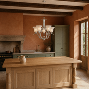 Terracotta kitchen | brushed nickel five-light chandelier above a pale oak island beneath dark beams