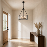 In a room | entryway view of the chandelier hanging beside a full-height door and walnut console