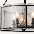 Texture | close view of the chandelier's hand-rippled clear water-glass panel and black iron edge