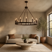 Greige living room | oil-rubbed bronze 12-light chandelier above a round travertine table