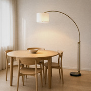Room 1 | antique-brass arched floor lamp beside a round oak dining table