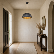 In an entryway | the dome pendant hanging in the walkway beside a console table and mirror