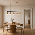 In a dining room | five-globe pendant shown beside a full-height doorway for scale