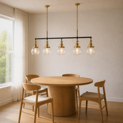 Three-quarter dining-room view | five-globe pendant over a round wood table