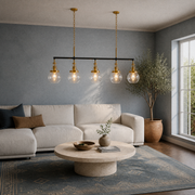 In a cool blue-gray living room | five-globe pendant over a travertine coffee table